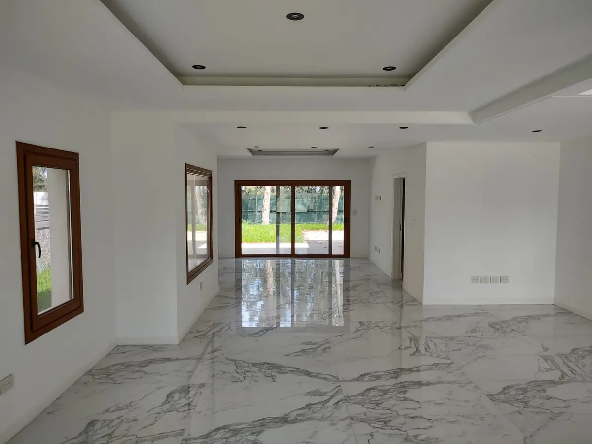 Sala de estar moderna com piso e paredes de mármore branco, janelas amplas — projeto Casa en el barrio de Saint Thomas Oeste, por Ves Arquitectura, em Canning